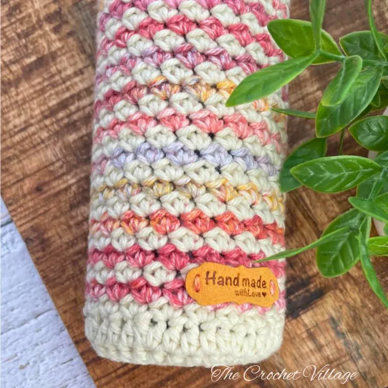 Detailed view of Aria crochet wine bag displaying textured one-row repeat stitch, color pattern, and handmade label tag
