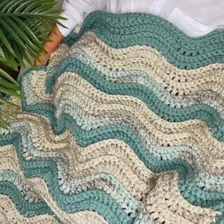 Crochet ripple blanket showing soft rolling wave peaks and valleys in teal and cream
