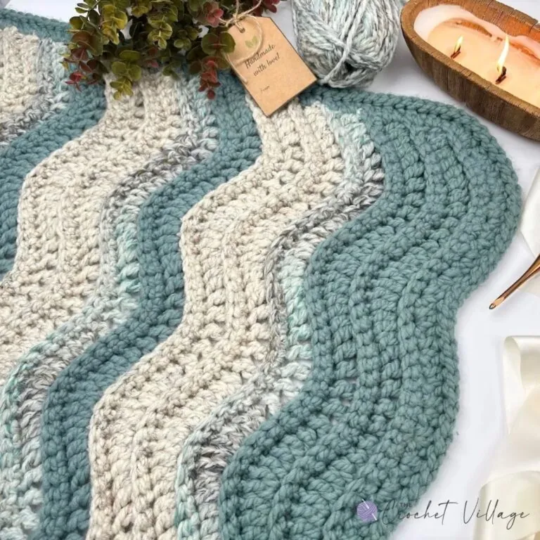 Close up of chunky crochet wave stitch texture in teal and cream super bulky yarn