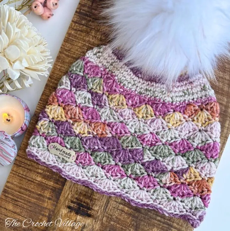 Meadow Hat crochet beanie with pom pom displayed on wooden surface - free pattern