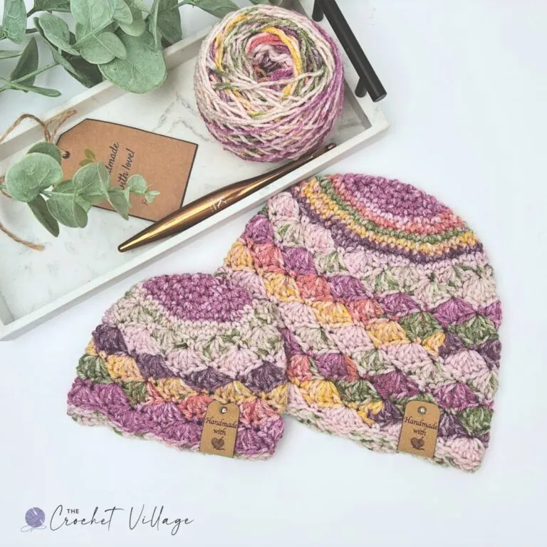 Two variegated purple and pink crochet shell stitch beanies with handmade gift tags