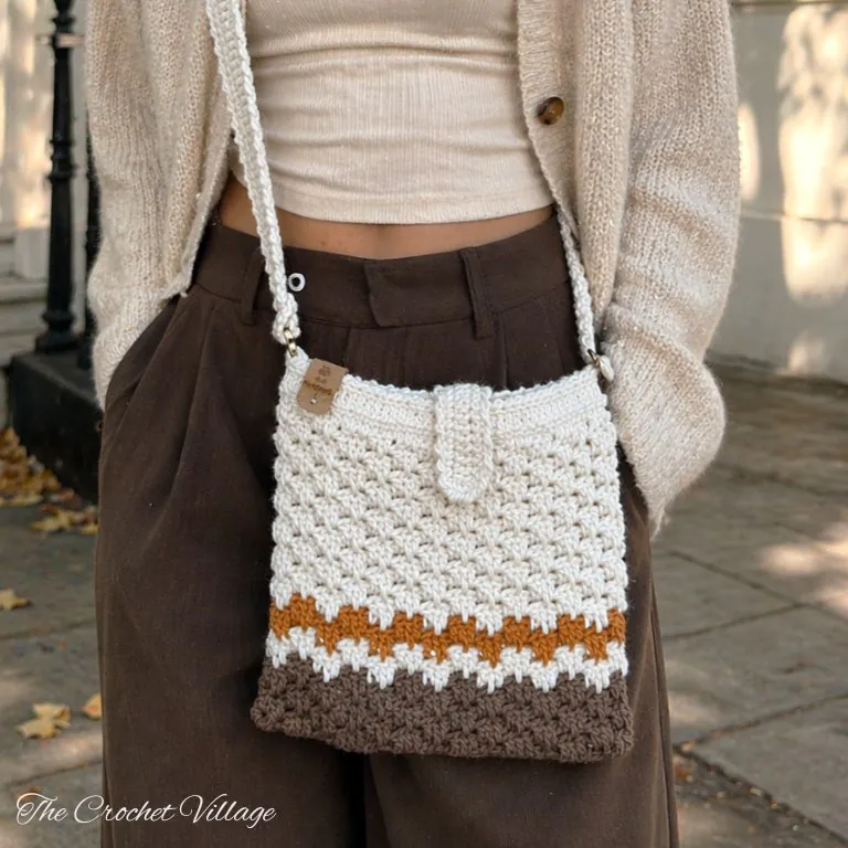 Woman carrying the Macchiato Bag, a stylish crochet crossbody bag made from the free crochet pattern.