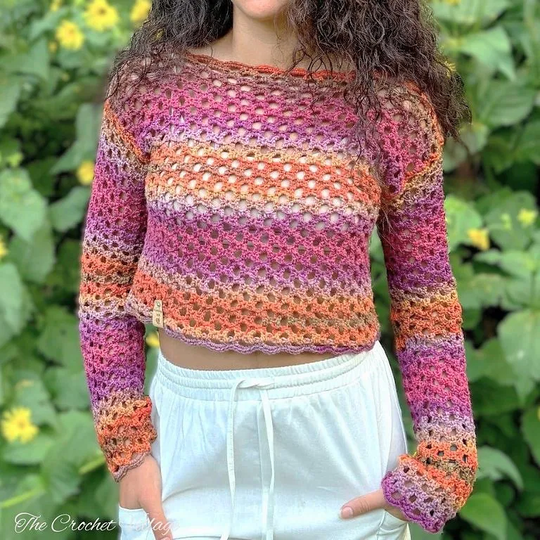 Model wearing a crochet mesh sweater in bold variegated yarn, lightweight long sleeve summer top with airy stitch pattern