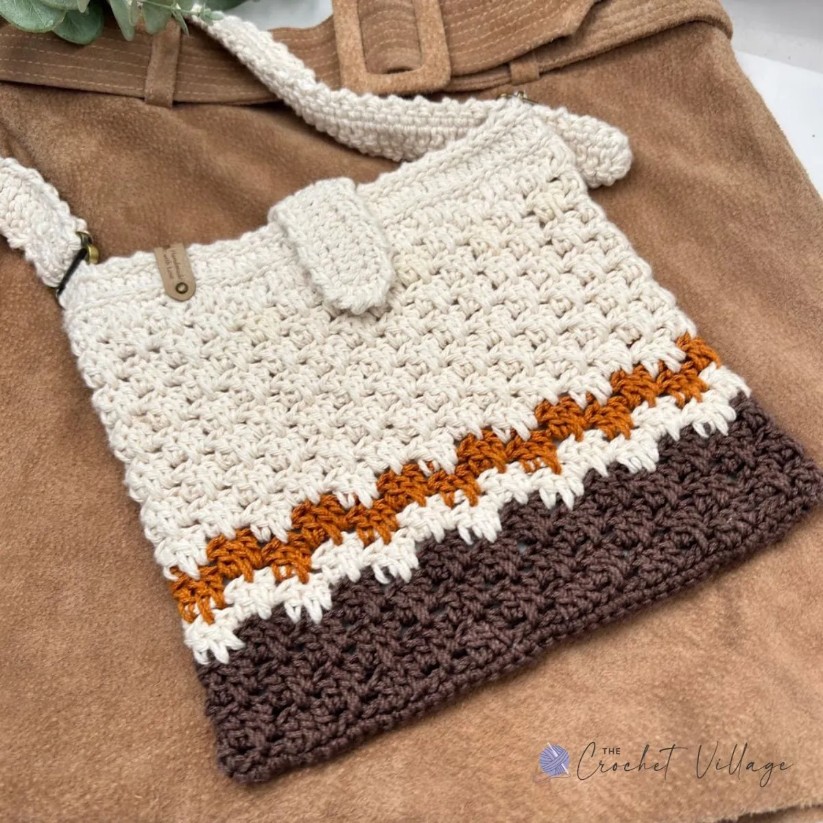Woman carrying the Macchiato Bag, a stylish crochet crossbody bag made from the free crochet pattern.