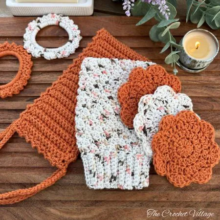 Free crochet bath set pattern featuring a back scrubber, textured shower mitt, reusable face rounds, and hair scrunchies in papaya cotton yarn.