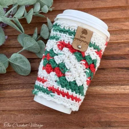 Joy Cup Cozy free crochet pattern - textured crochet coffee sleeve on a white ceramic mug