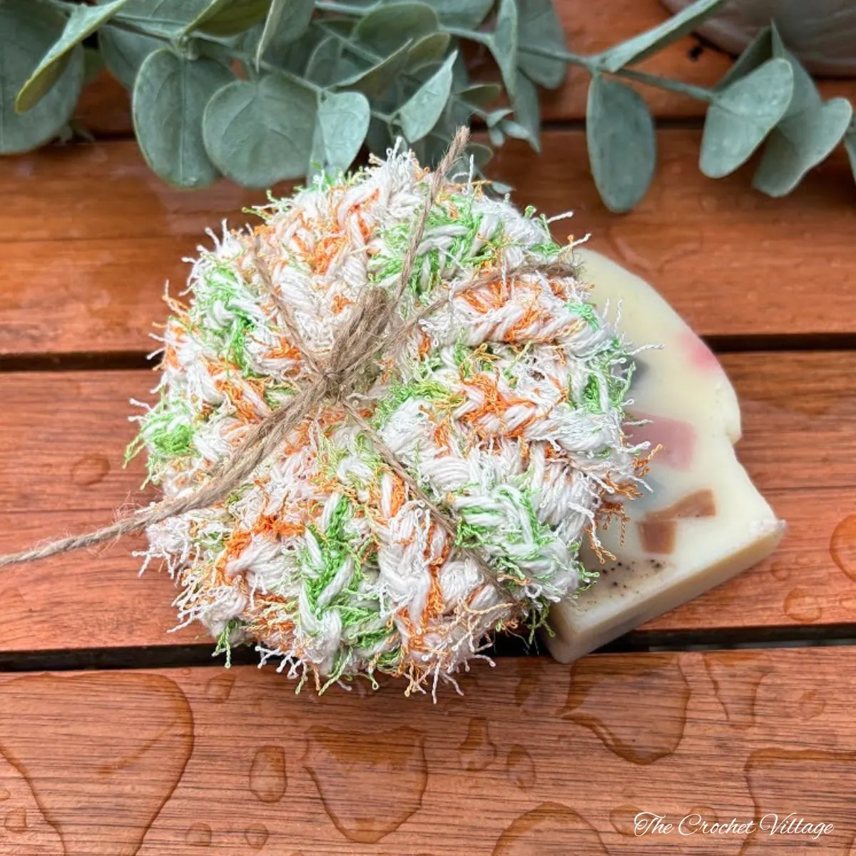 Free crochet scrubbies pattern — round scrub puck tied with twine beside handmade soap