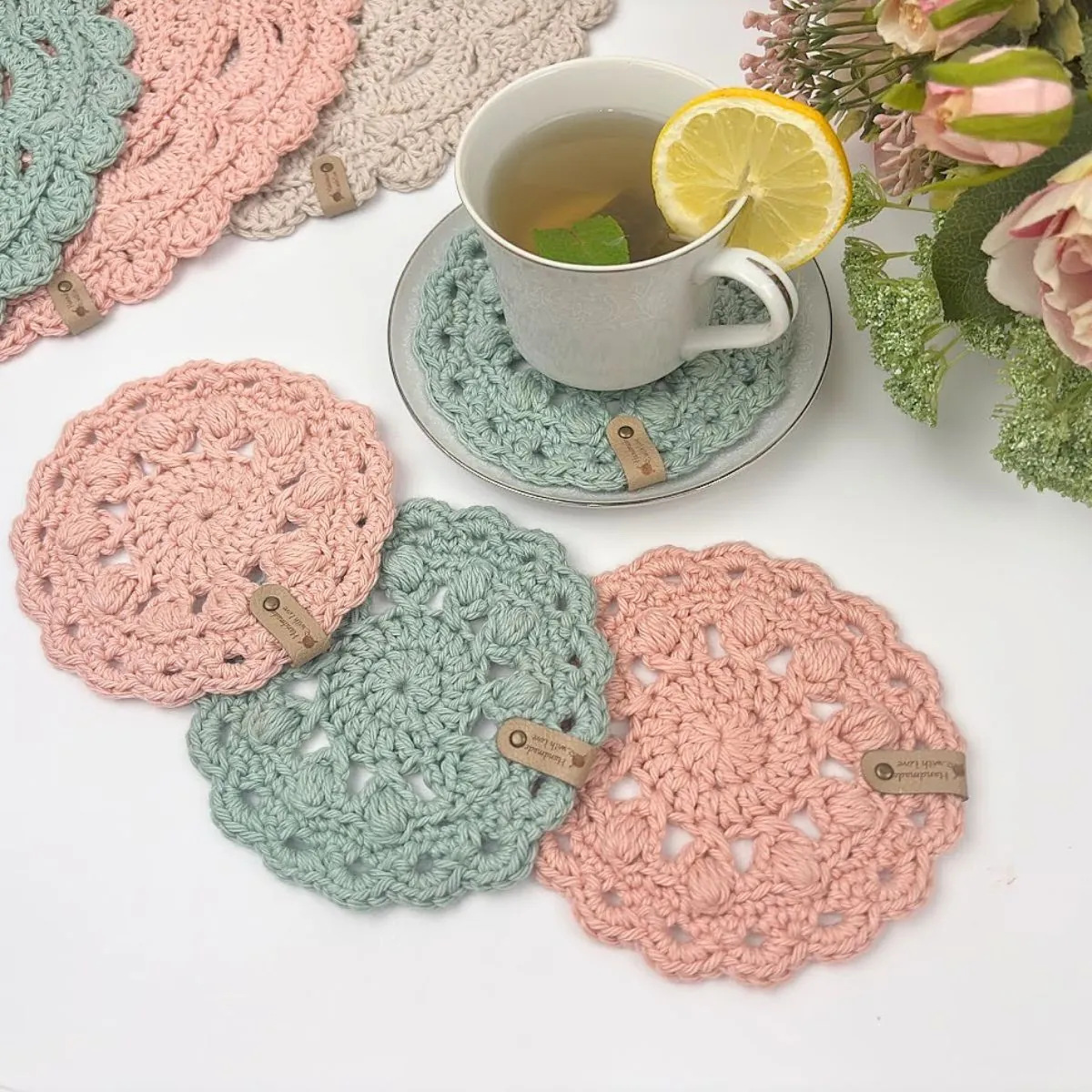 Teacup resting on an easy crochet coaster made with worsted weight cotton yarn
