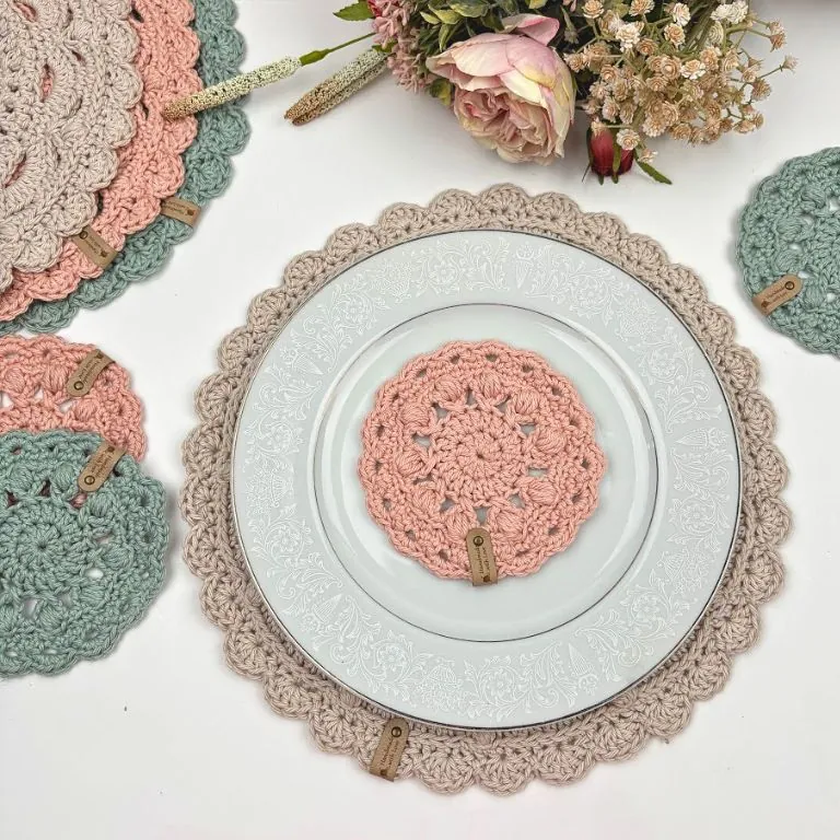 Free crochet placemat and coaster pattern in blush, sage green, and cream cotton with faux leather tags