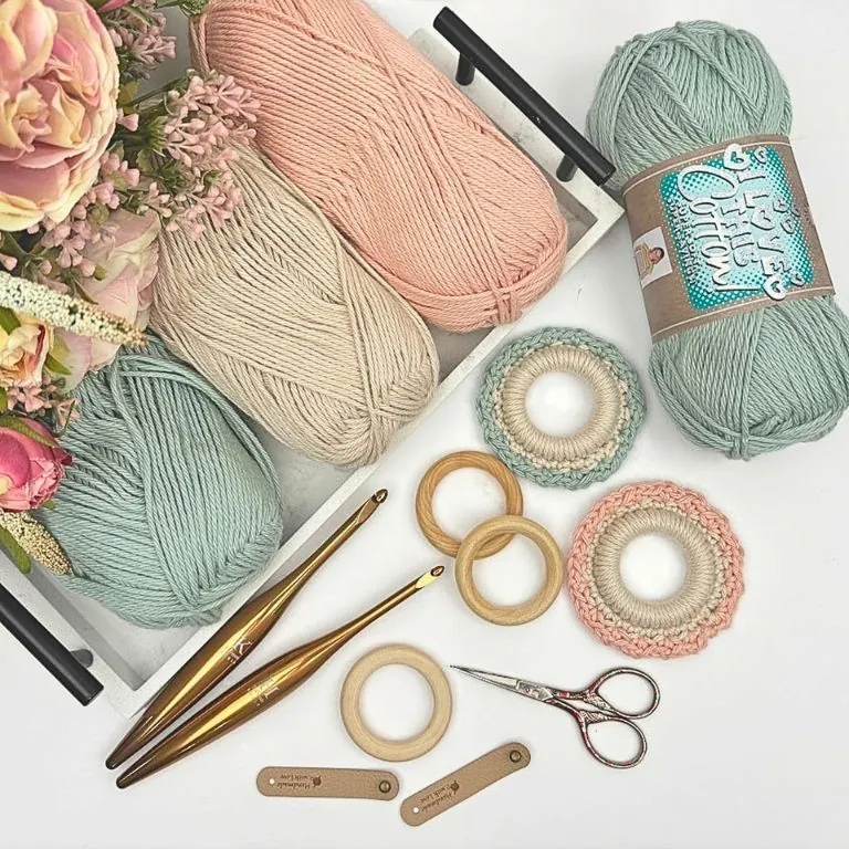 Crochet supplies flat lay with I Love This Cotton yarn, wooden rings, crochet hooks, and a napkin holder