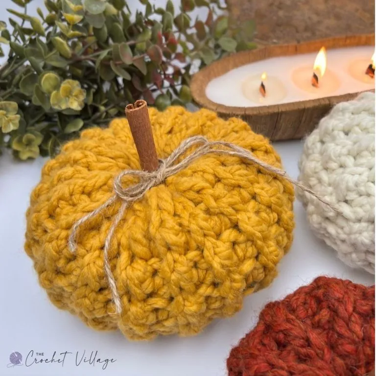 Mustard yellow chunky crochet pumpkin with cinnamon stick stem and twine bow, made in super bulky yarn — free easy crochet pumpkin pattern