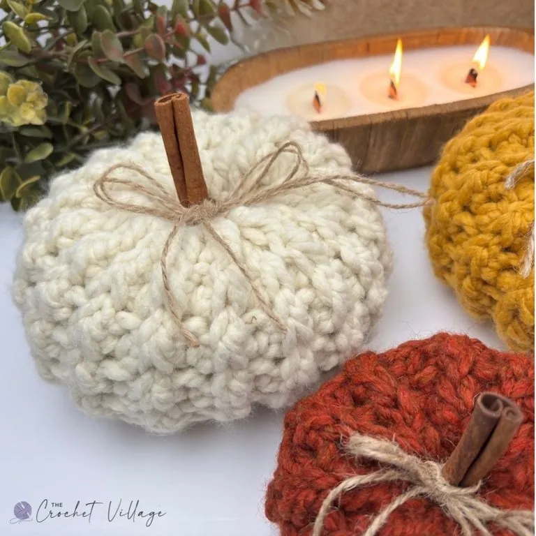 Close-up of a cream chunky crochet pumpkin with cinnamon stick stem and twine bow, showing the textured stitch detail — free easy crochet pumpkin pattern