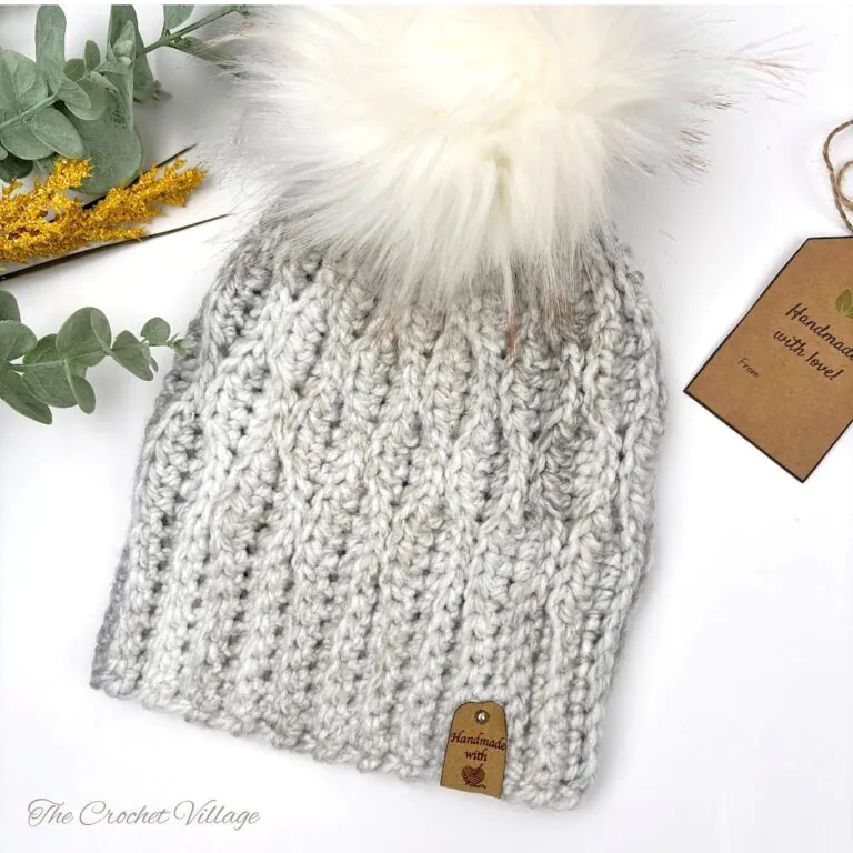 Geniva Hat – free bulky yarn crochet beanie in blue with pom-pom
