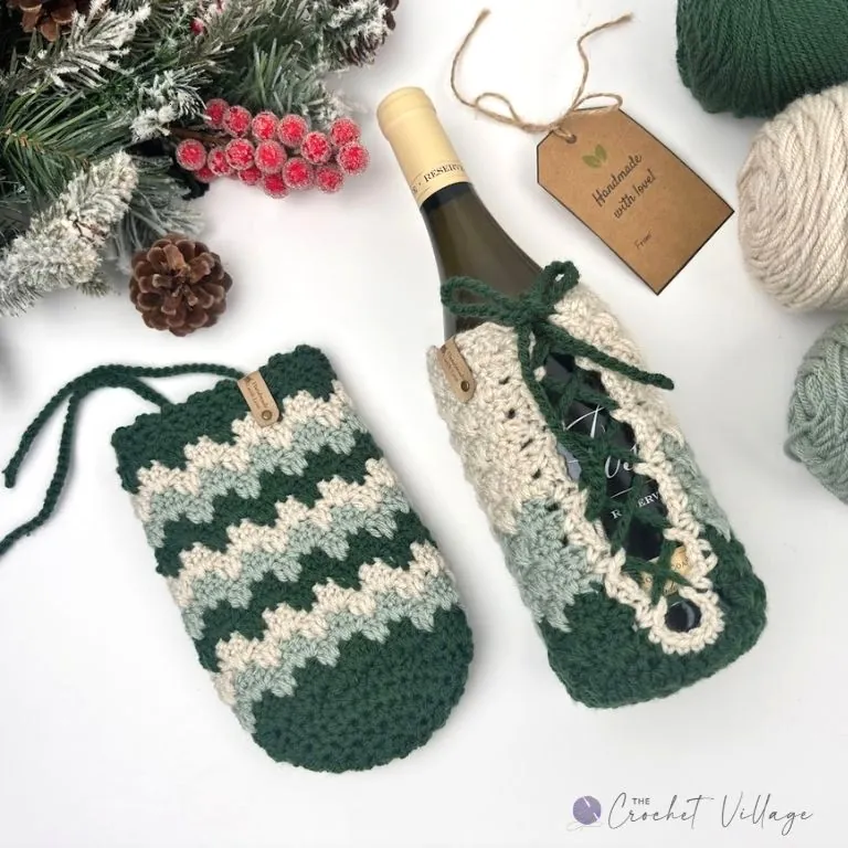 Crochet wine bottle cozy with laced-up back in green and cream, shown on a bottle with the label peeking through