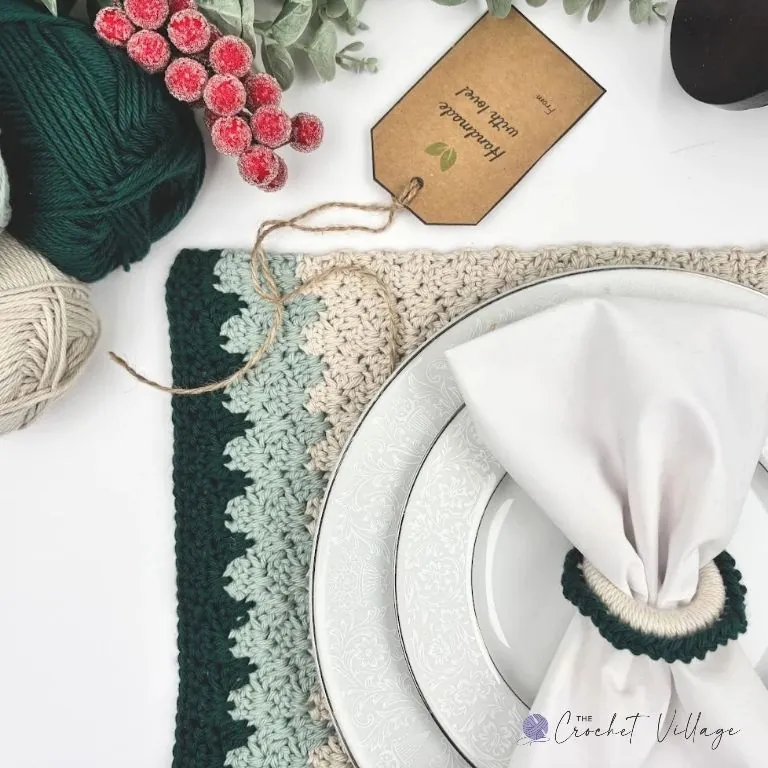 Crochet placemat and napkin ring on a holiday table setting in sage and forest green